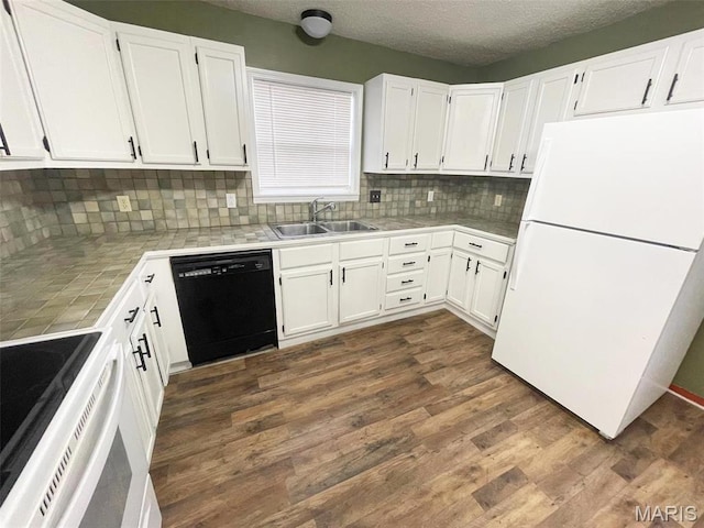 kitchen featuring white appliances, a sink, tile countertops, backsplash, and white cabinetry