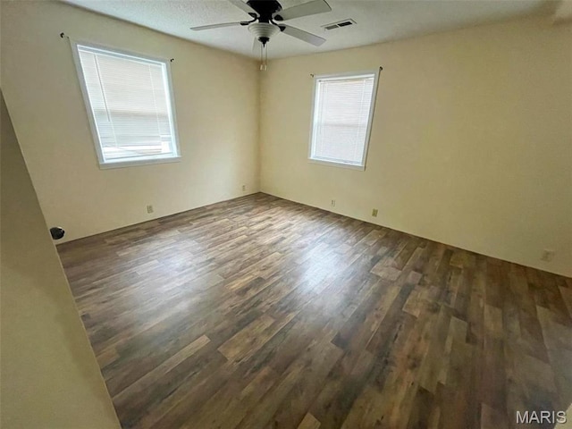 unfurnished room featuring dark wood-type flooring and ceiling fan