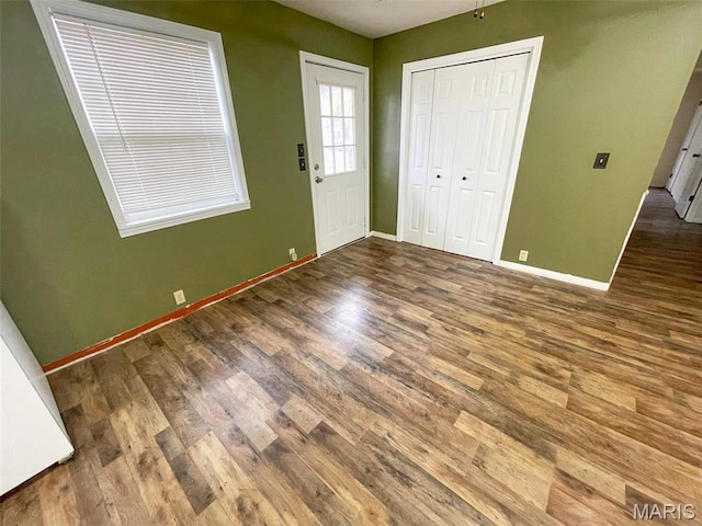 entrance foyer featuring baseboards and wood finished floors