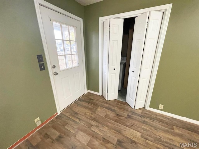 doorway to outside with baseboards and dark wood-type flooring