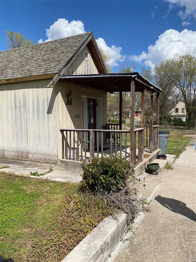 view of home's exterior with a shingled roof and a porch