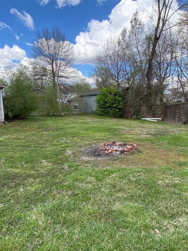 view of grassy yard featuring a fire pit