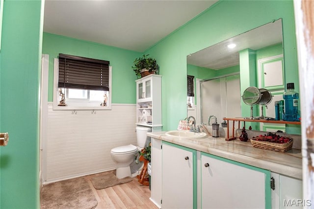 12650 State Route W, Rolla, MO 65401 - bathroom featuring toilet, vanity, wood finished floors, a shower with door, and a wainscoted wall