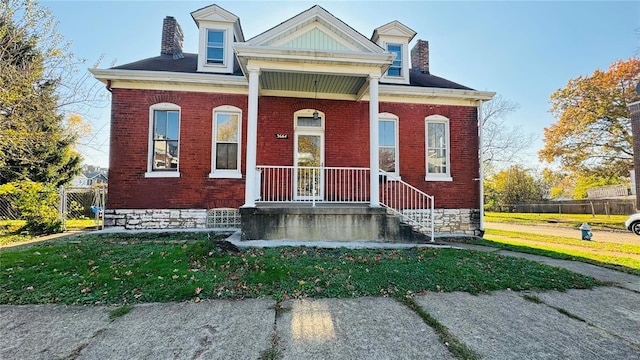 view of front facade featuring brick siding, a chimney, and fence
