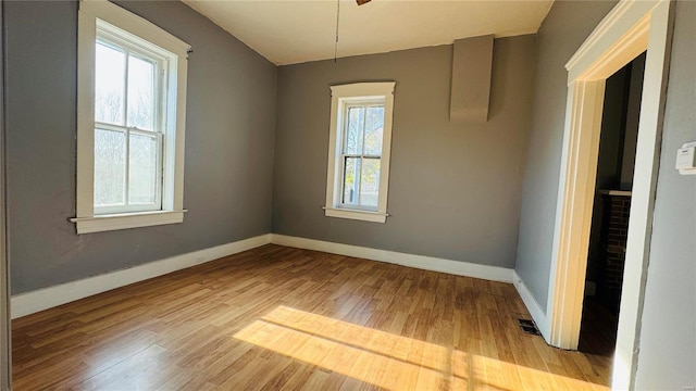 unfurnished room featuring wood finished floors, baseboards, and a ceiling fan