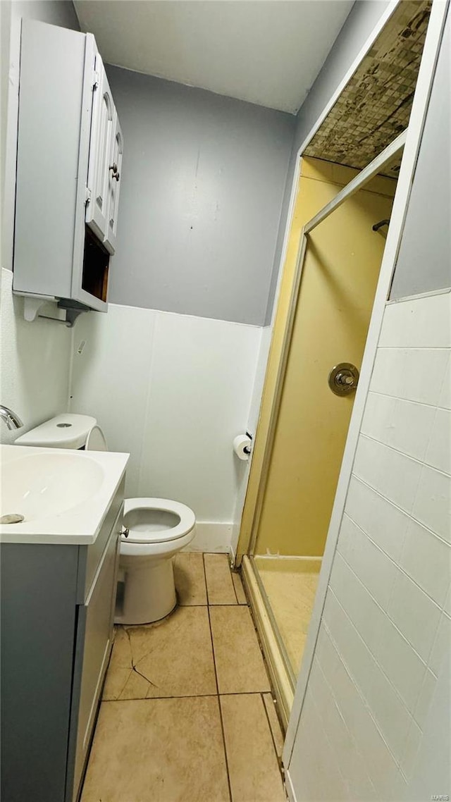 full bathroom featuring a stall shower, tile patterned floors, vanity, and toilet