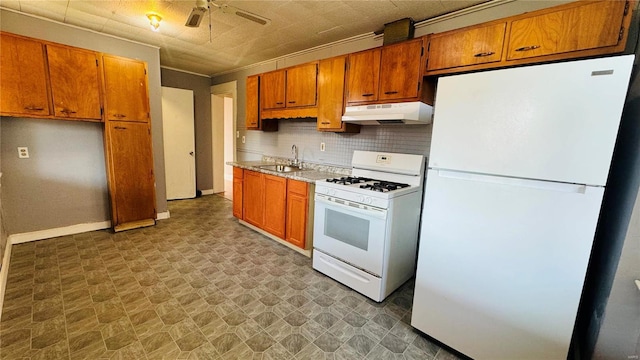 kitchen with white appliances, under cabinet range hood, a sink, ceiling fan, and light countertops