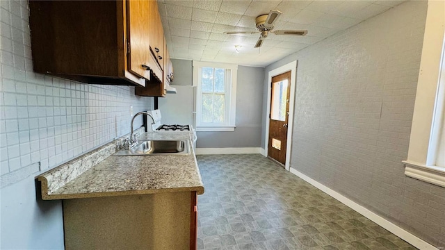 kitchen featuring a sink, light countertops, baseboards, ceiling fan, and tile patterned floors