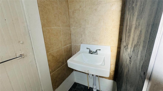 bathroom featuring a sink and tile walls