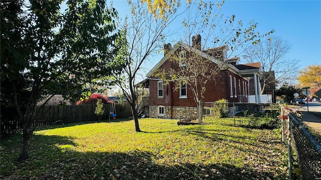 view of side of property featuring brick siding and a chimney
