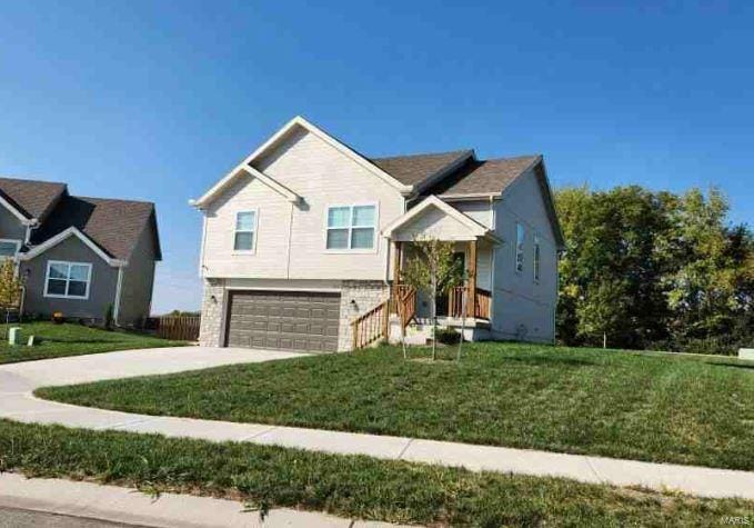 view of front of property with driveway, a front lawn, and a garage