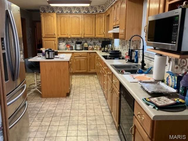 36180 State Highway 25, Malden, MO 63863 - kitchen with black appliances, a sink, light countertops, a kitchen island, and under cabinet range hood