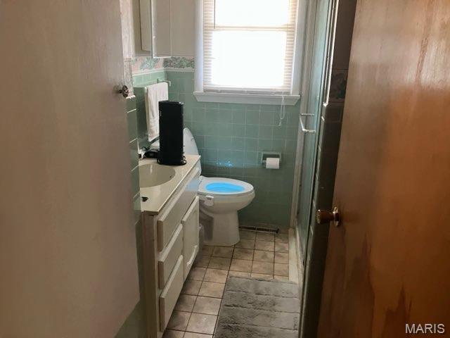 36180 State Highway 25, Malden, MO 63863 - full bath featuring tile patterned flooring, vanity, toilet, tile walls, and a shower stall