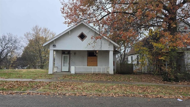bungalow-style home featuring a porch and stucco siding