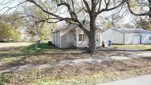 604 N 3rd St, Hayti, MO 63851 - view of front of house featuring a detached garage, an outbuilding, central AC unit, and a porch