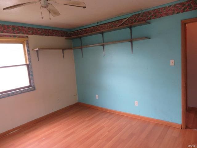 empty room with light wood-type flooring, ceiling fan, and baseboards