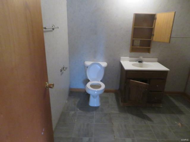 bathroom featuring toilet, vanity, and tile patterned flooring