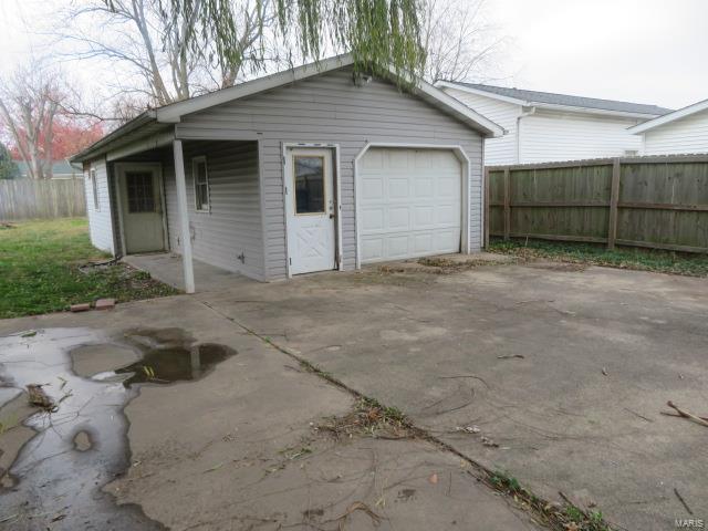 detached garage with driveway and fence
