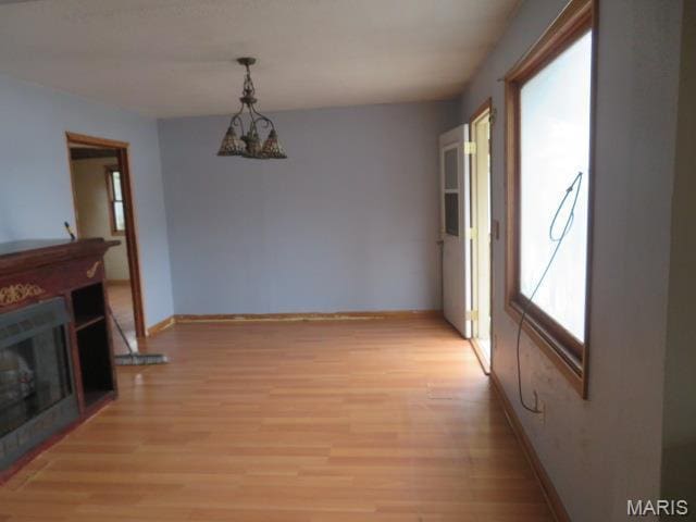 817 S Montgomery Ave, Litchfield, IL 62056 - unfurnished dining area featuring light wood finished floors, baseboards, and a fireplace