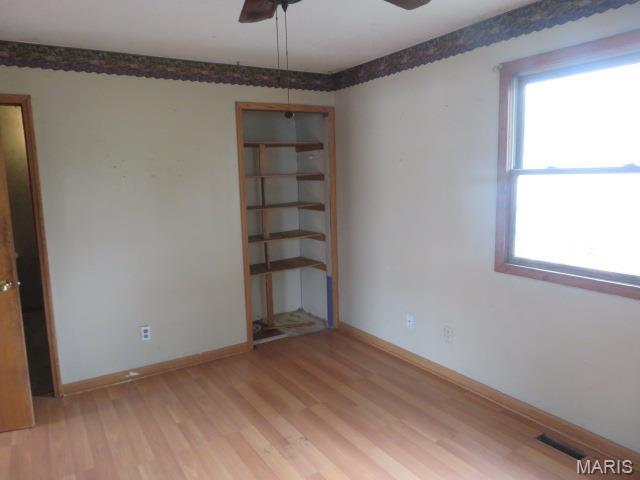 817 S Montgomery Ave, Litchfield, IL 62056 - spare room featuring light wood finished floors, plenty of natural light, a ceiling fan, and baseboards