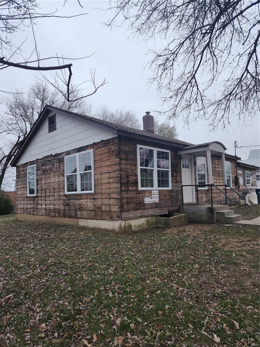 303 S Pine St, Dixon, MO 65459 - view of side of home featuring a chimney