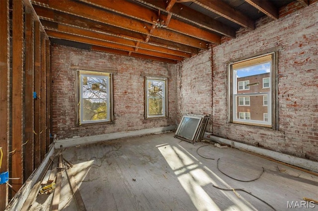 5872 Cabanne Ave, Saint Louis, MO 63112 - miscellaneous room with plenty of natural light, brick wall, wood finished floors, and baseboards