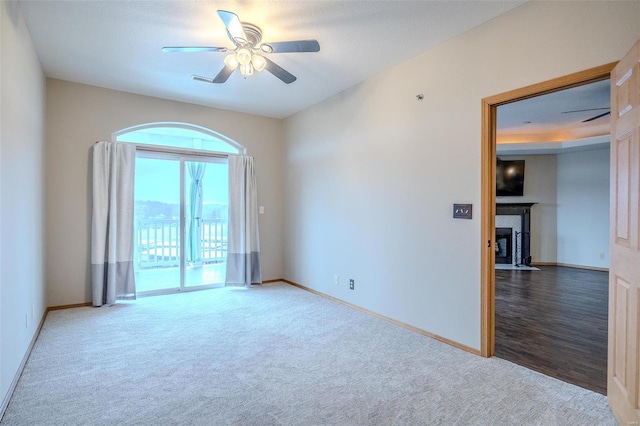 49 Aqua Finn Dr Unit 4A, Lake Ozark, MO 65049 - carpeted spare room with baseboards, ceiling fan, and a fireplace with flush hearth