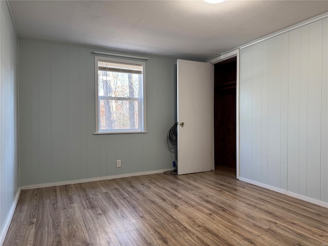 unfurnished bedroom featuring wood finished floors and a textured ceiling