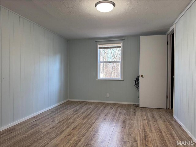 839 Bluebird Ln, Doniphan, MO 63935 - unfurnished room with wood finished floors, a textured ceiling, and baseboards