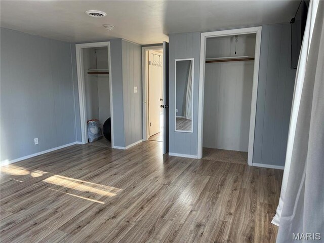 839 Bluebird Ln, Doniphan, MO 63935 - unfurnished bedroom featuring multiple closets, wood finished floors, and baseboards