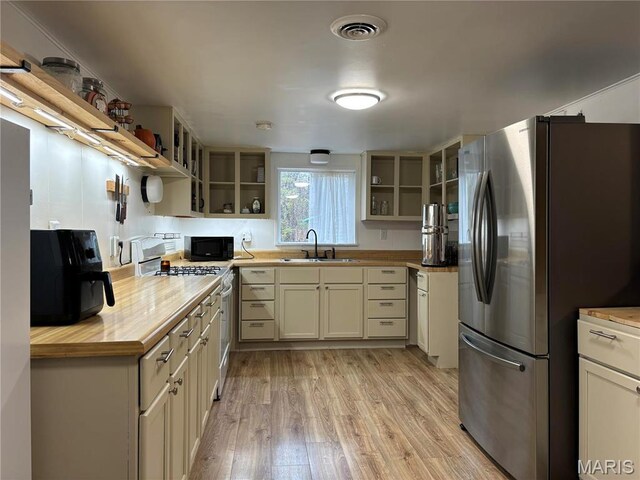 839 Bluebird Ln, Doniphan, MO 63935 - kitchen with freestanding refrigerator, open shelves, range with gas cooktop, black microwave, and a sink