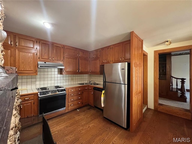 315 E Madison St, Paris, MO 65275 - kitchen featuring stainless steel appliances, tile counters, dark wood finished floors, a sink, and under cabinet range hood