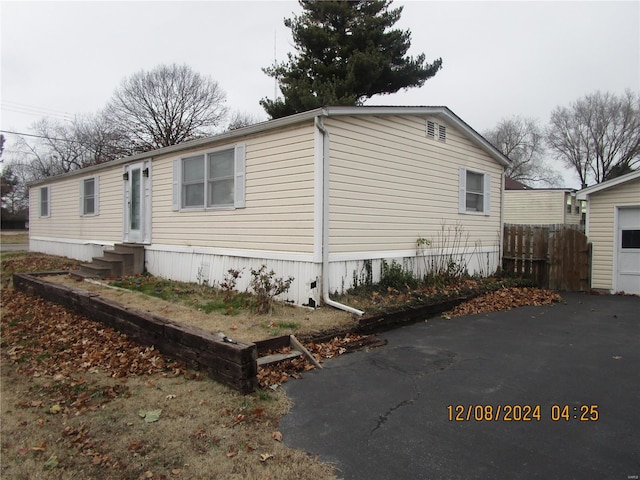 view of side of property with fence and entry steps