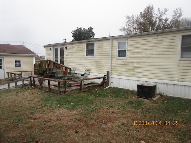 rear view of house featuring french doors, a lawn, central AC, and a wooden deck
