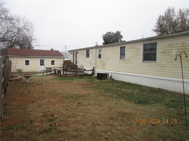 rear view of house with a lawn and central air condition unit