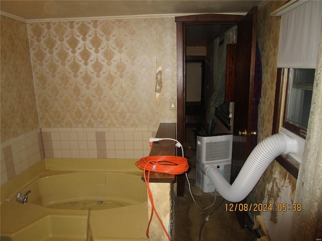 bathroom featuring wallpapered walls and a bath