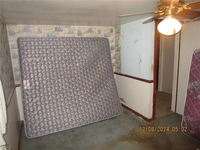 spare room featuring unfinished concrete flooring and a ceiling fan