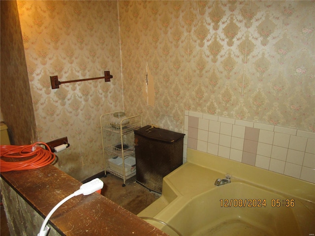 bathroom featuring wallpapered walls and a bath