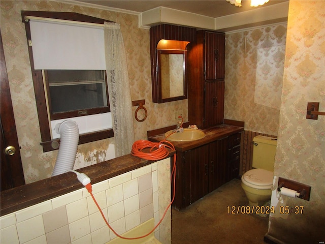 bathroom featuring wallpapered walls, toilet, and vanity