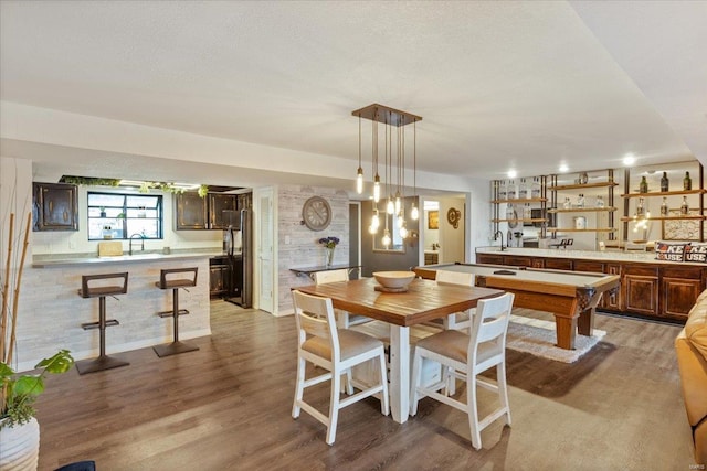 dining area with wet bar and wood finished floors