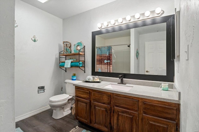 bathroom featuring wood finished floors, toilet, vanity, curtained shower, and baseboards