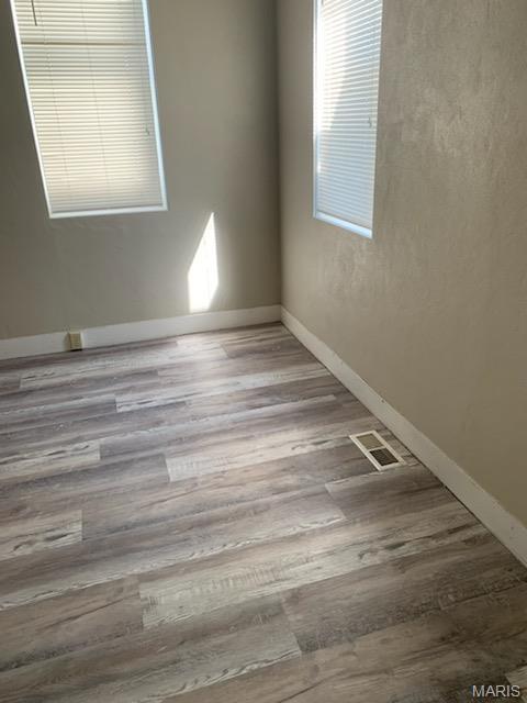 unfurnished room featuring wood finished floors and baseboards
