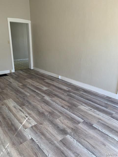 empty room featuring wood finished floors and baseboards