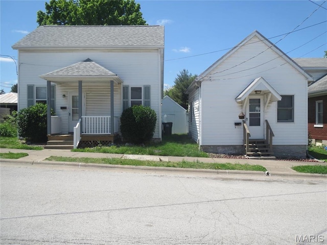 bungalow with entry steps, a porch, and central air condition unit
