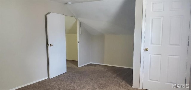 additional living space featuring carpet floors, vaulted ceiling, and baseboards