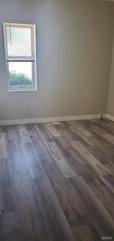 spare room featuring wood finished floors and baseboards
