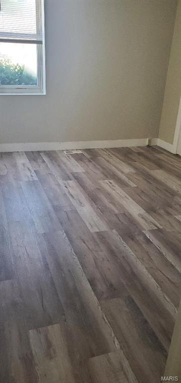 spare room featuring wood finished floors and baseboards