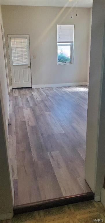 empty room featuring wood finished floors and baseboards