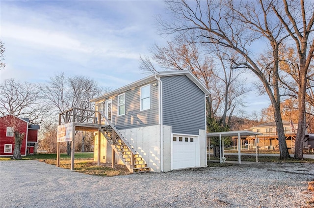 1100 W Main St, Grafton, IL 62037 - view of side of property featuring stairway, a carport, gravel driveway, and an attached garage