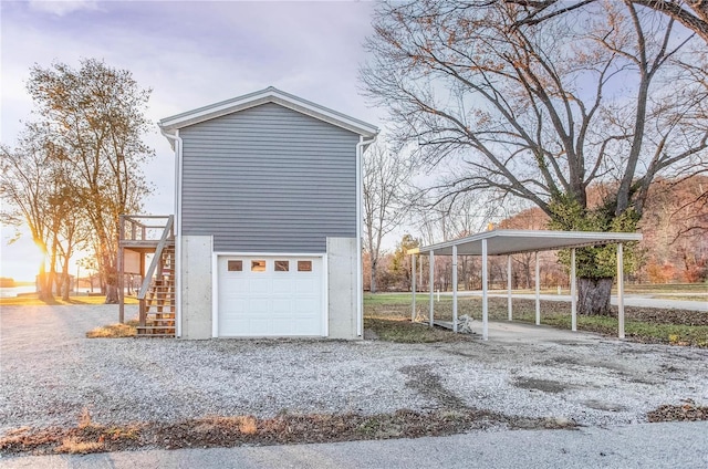 1100 W Main St, Grafton, IL 62037 - view of property exterior with an attached garage, stairs, a detached carport, and gravel driveway